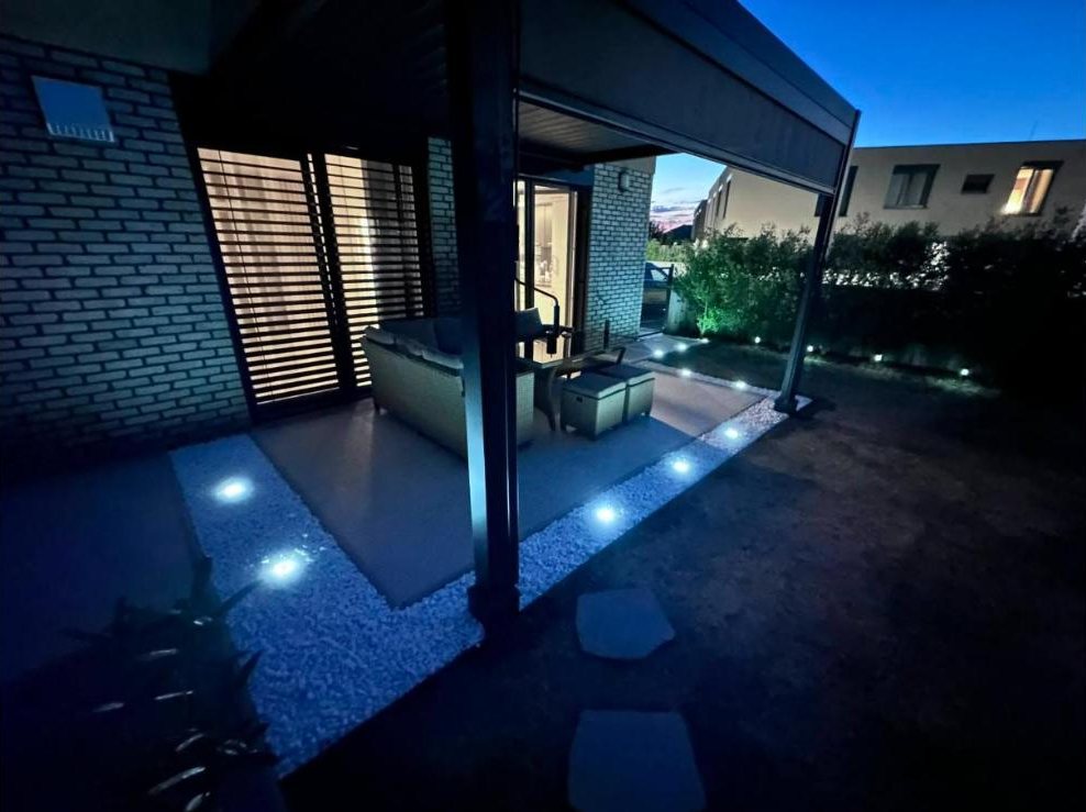 Pergola s osvetlením a okrasným kameňom večer